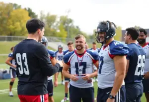 Comedian Adam Sandler interacting with University of Kentucky athletes during a sports practice event.