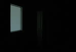 A closet partially open in a dimly lit room.