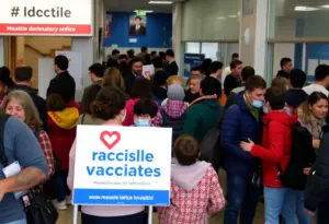 A public health awareness poster on measles vaccination in a clinic setting.